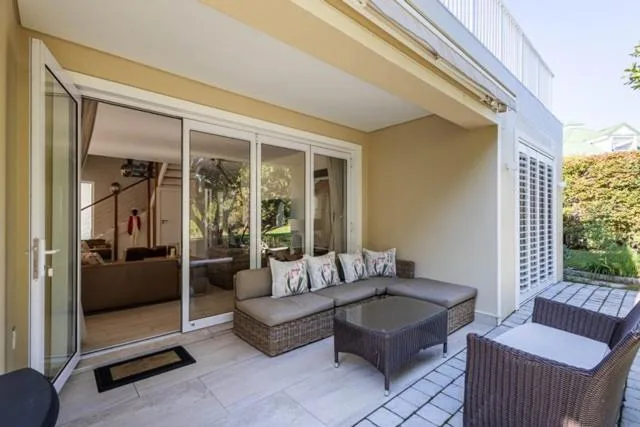 Covered patio with wicker seating furniture and glass doors opening to lounge