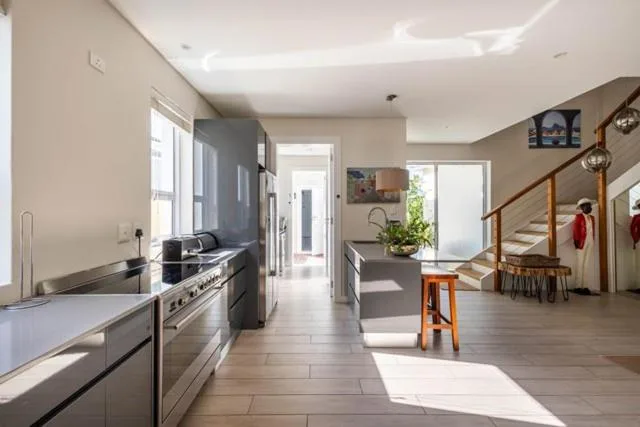 Modern kitchen with stainless steel appliances and open-plan living space