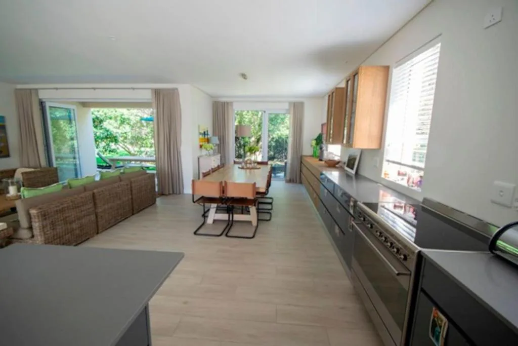 Open-plan lounge with sofa, dining table, and kitchen area visible