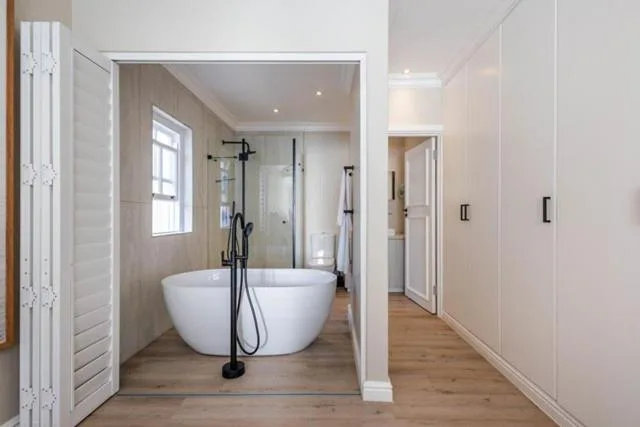 Modern bathroom with freestanding white soaking tub and rainfall shower