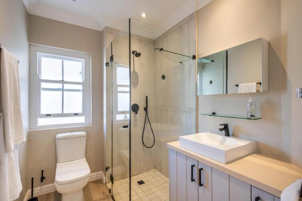 Modern bathroom with walk-in shower, vanity sink, and toilet