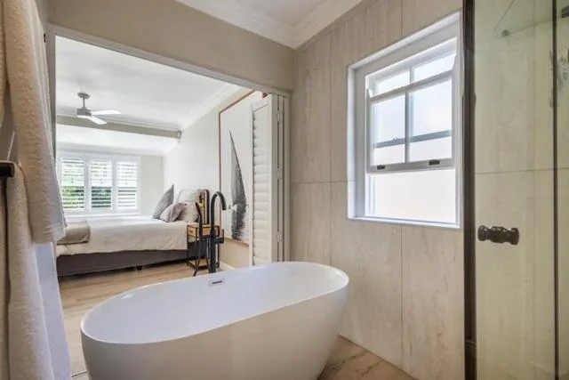 Modern bathroom with freestanding white bathtub and rainfall showerhead