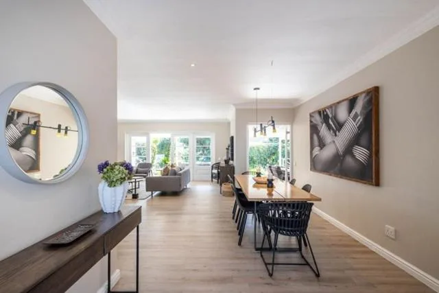 Modern dining area with black chairs and wooden table in open-plan home