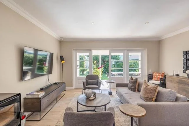 Spacious lounge with sofa, TV, fireplace and garden views