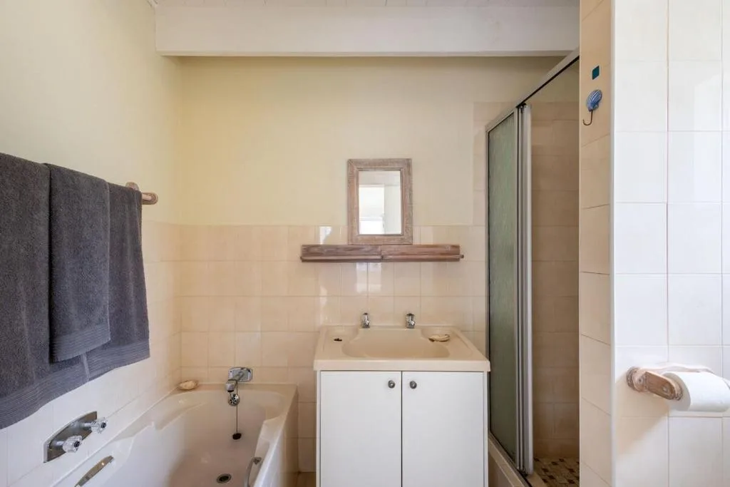 Clean bathroom with vanity, mirror, bathtub, and shower enclosure