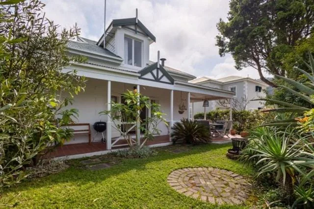 Cape Dutch style house with wraparound porch and manicured garden