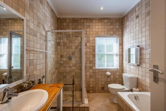 Spacious bathroom with double vanities, walk-in shower, and tiled walls