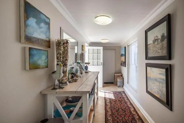 Hallway with console table, framed artwork, decorative accessories and bright lighting
