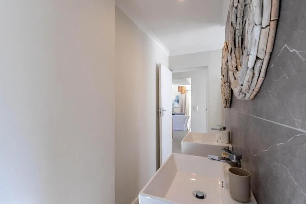 Modern bathroom with dual vanity sinks and grey marble tiling