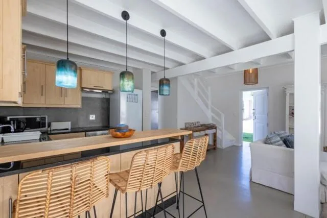 Modern kitchen with wooden cabinetry, island seating, and pendant lights