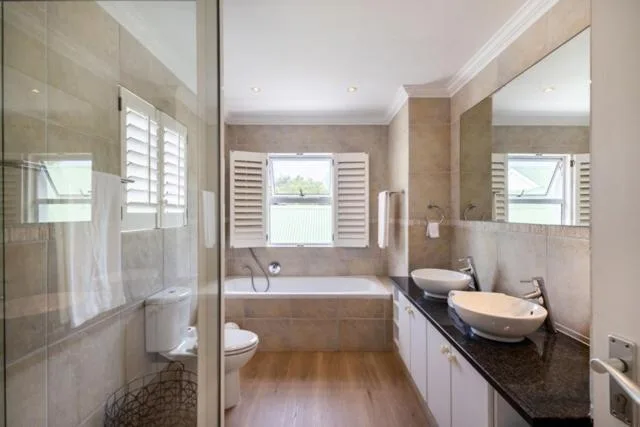Modern bathroom with double vanity, bathtub, and walk-in shower