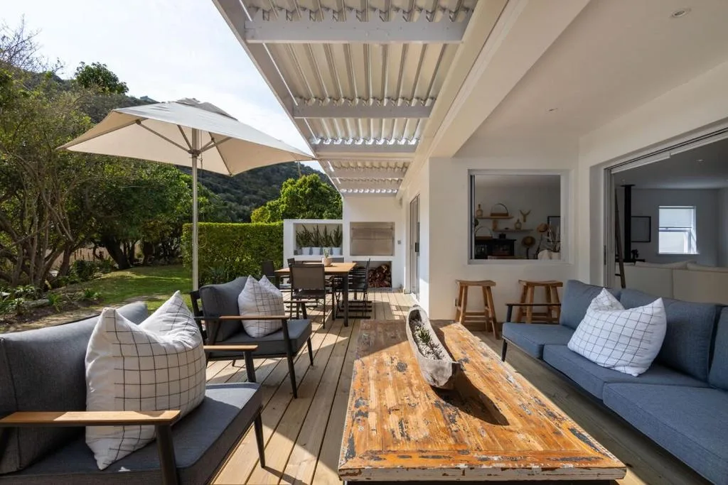 Spacious covered deck with lounge seating, dining table, and mountain views