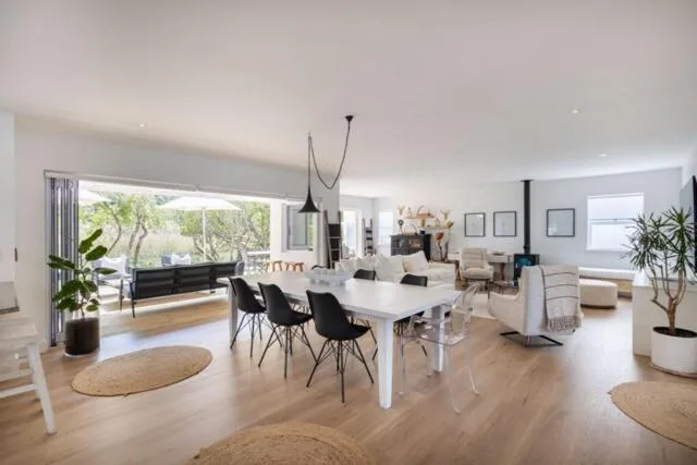 Open-plan living space with dining table, seating areas, and deck views