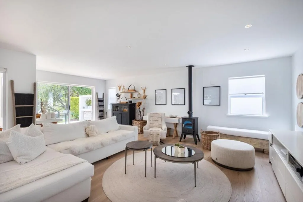 Spacious living room with cream sofa, wood stove, and modern decor