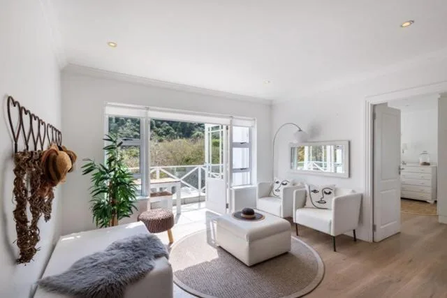 Bright lounge with cream seating, fireplace, and garden views through doors