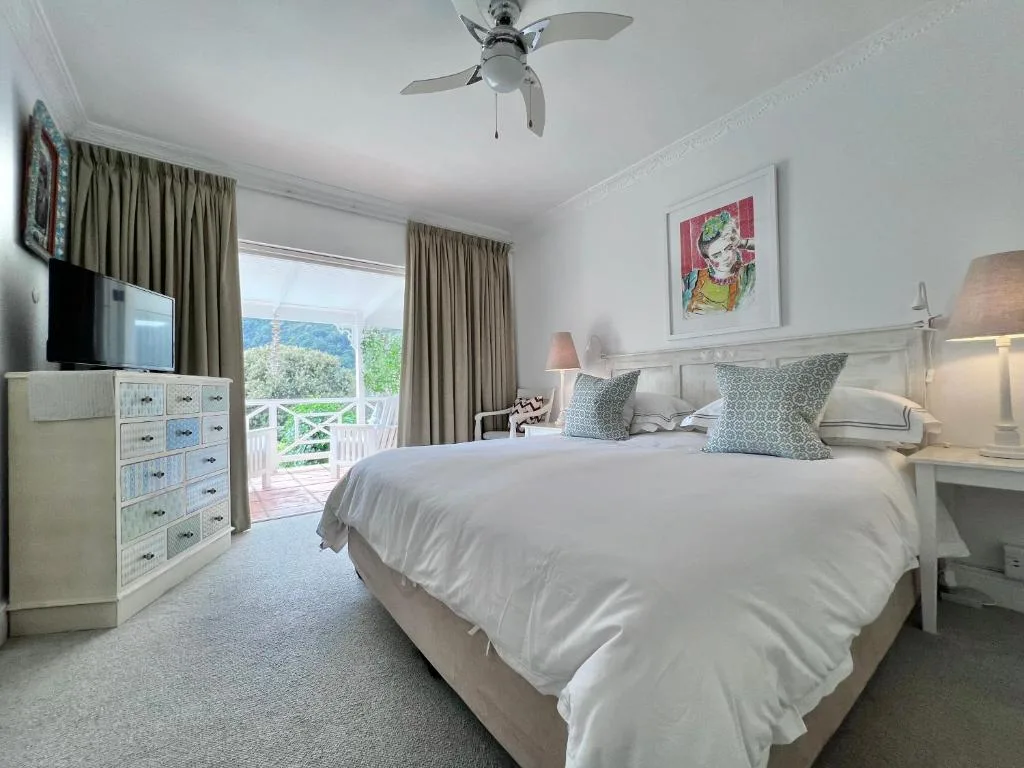 Bright bedroom with queen bed, mountain views through glass doors, and modern furnishings