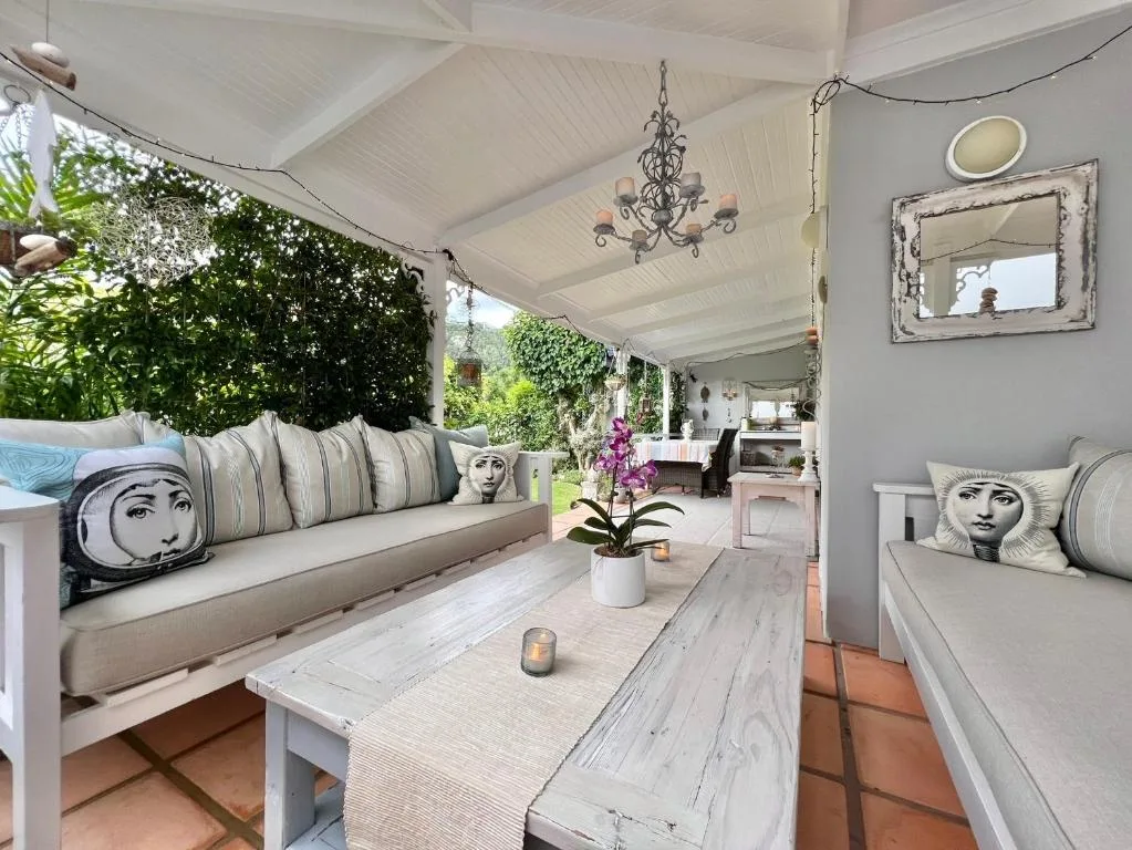 Covered patio with built-in seating, orchid centerpiece, and garden views