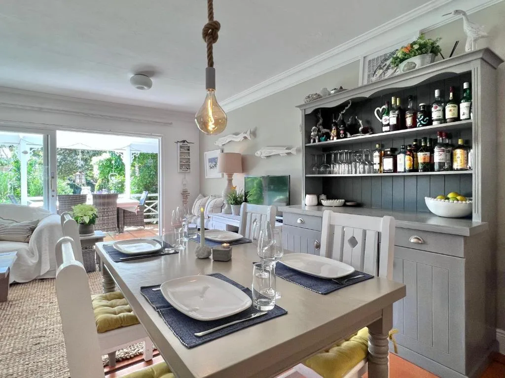 Elegant dining room with set table, open-plan kitchen, and garden view