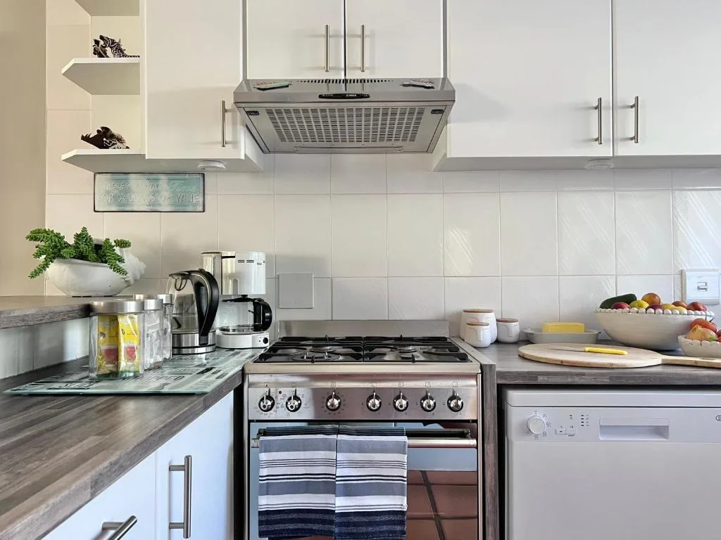 Modern kitchen with stainless steel gas range and white cabinetry