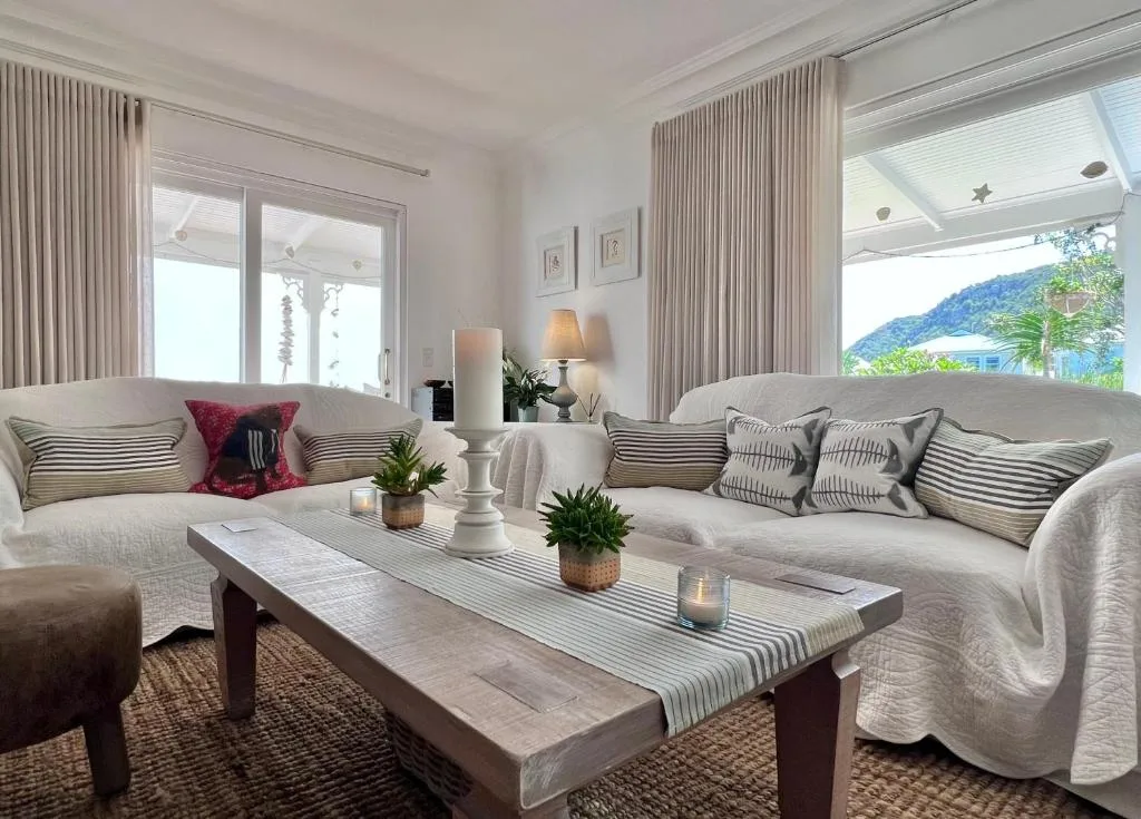 Bright lounge with cream sofas, mountain views through windows and doors