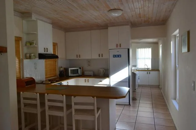 Modern kitchen with white cabinetry, island counter, and stainless steel appliances
