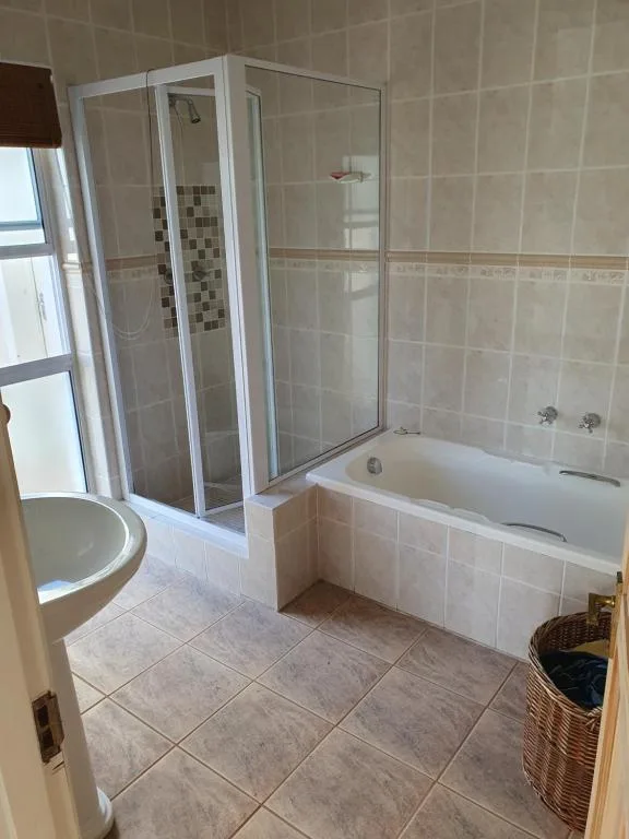 Spacious bathroom with shower enclosure, bathtub, and toilet fixtures