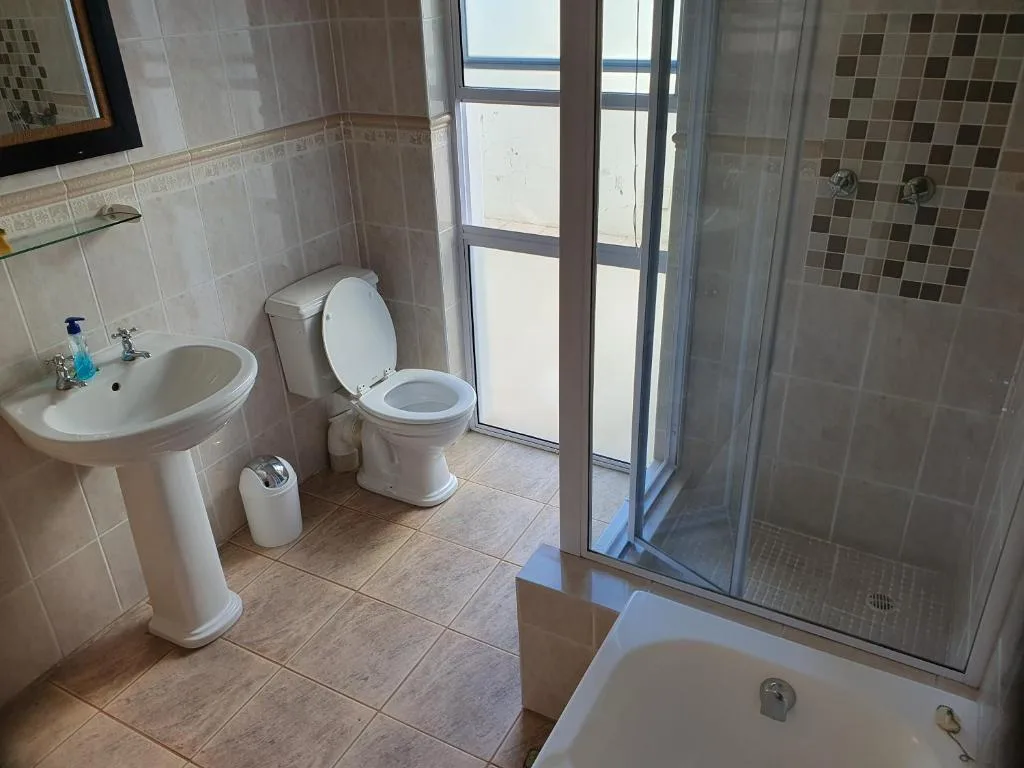 Bathroom with sink, toilet, shower enclosure and window view
