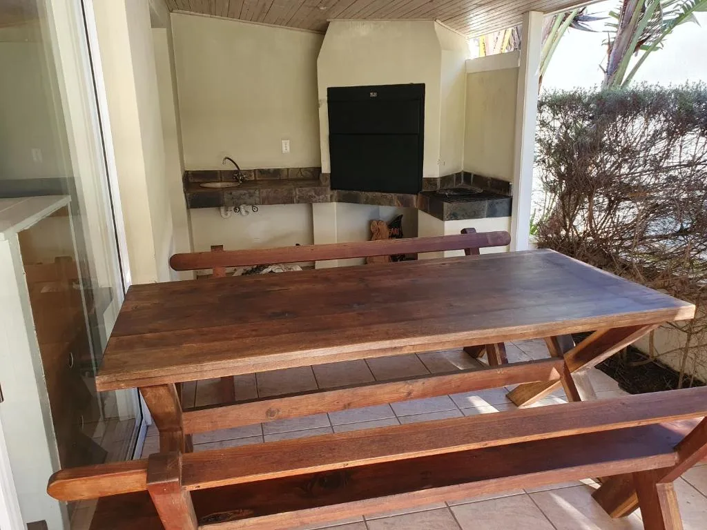 Wooden dining table and benches on covered outdoor patio area