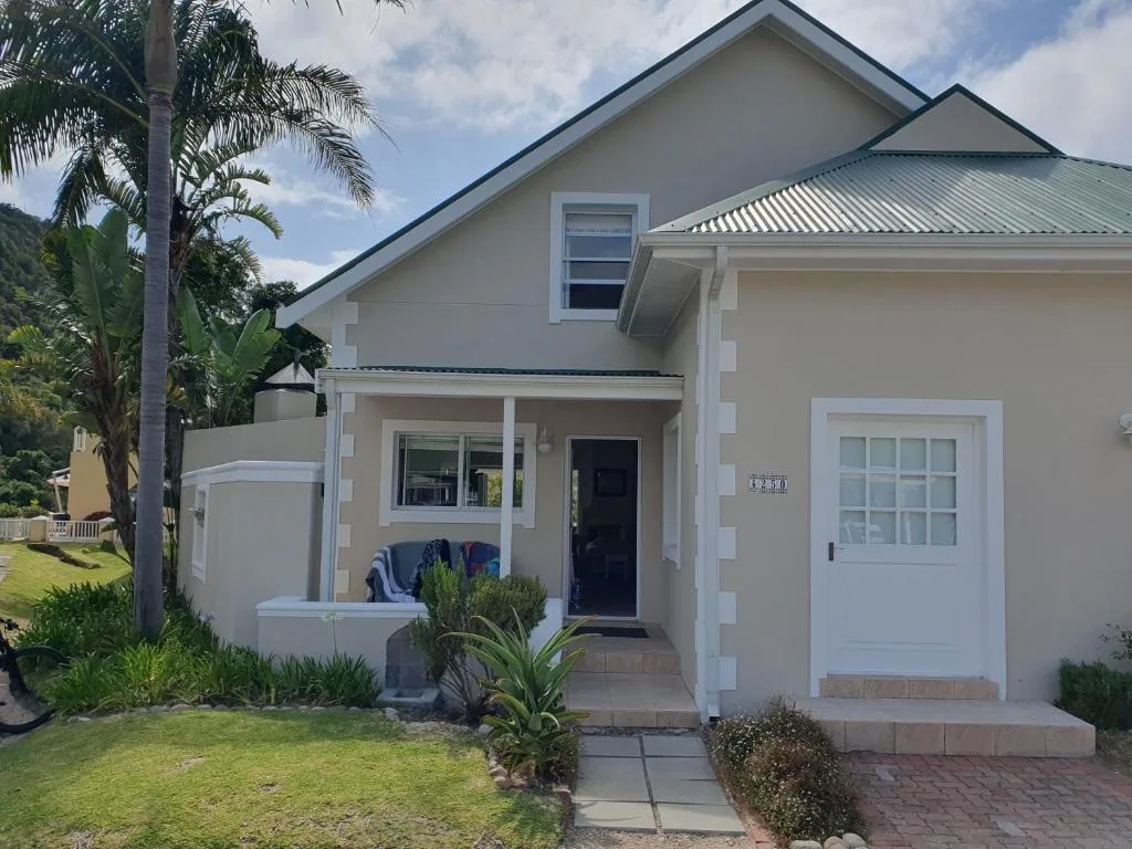 Modern white villa with green roof and manicured garden entrance