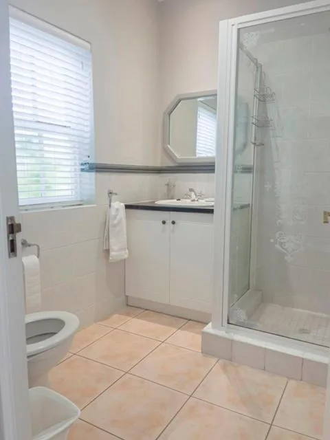 Clean bathroom with shower enclosure, vanity sink, and toilet