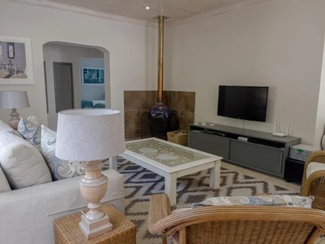 Bright living room with white sofa, fireplace, and flat-screen television