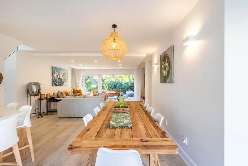Open-plan dining and lounge area with wooden table and garden views