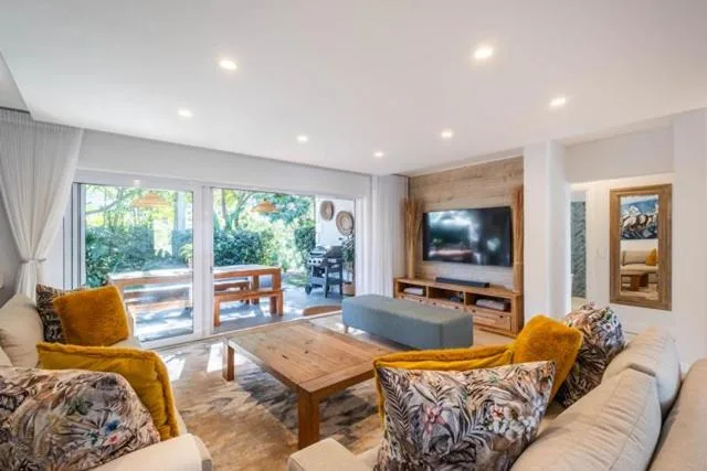 Spacious lounge with sofas, wooden coffee table, and flat-screen TV