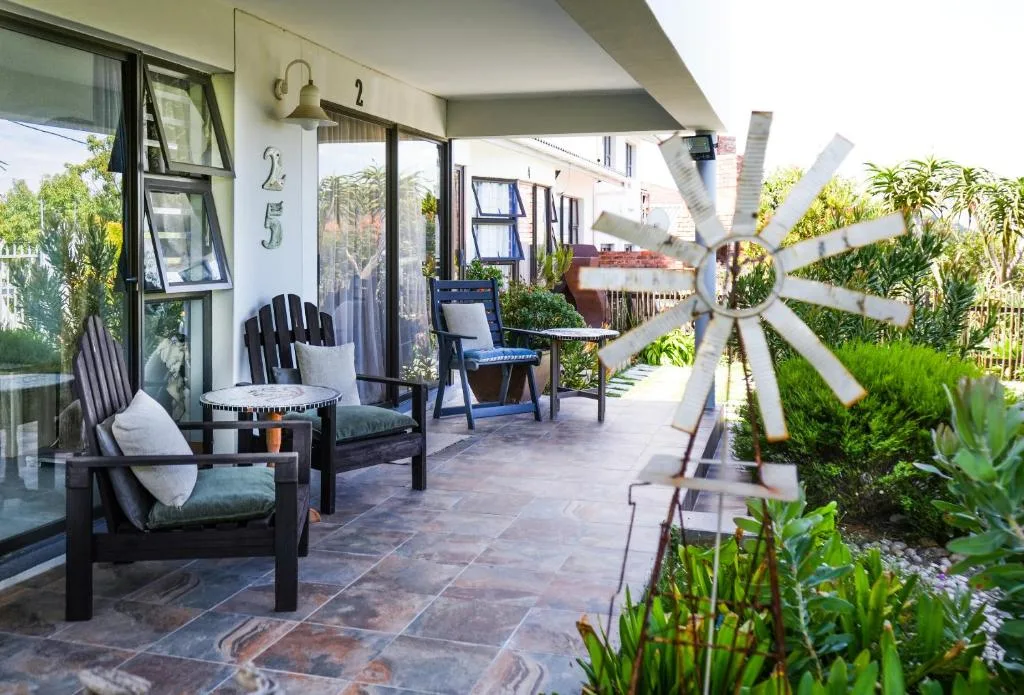 Patio with black Adirondack chairs and garden views overlooking lush landscaping