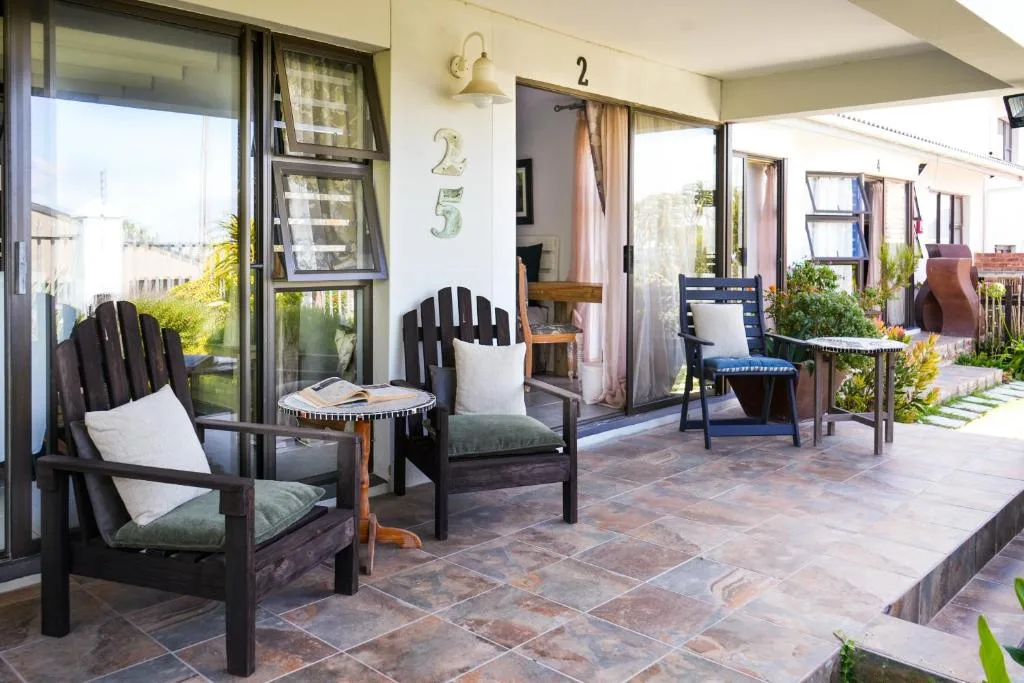 Spacious covered patio with black Adirondack chairs and ocean views