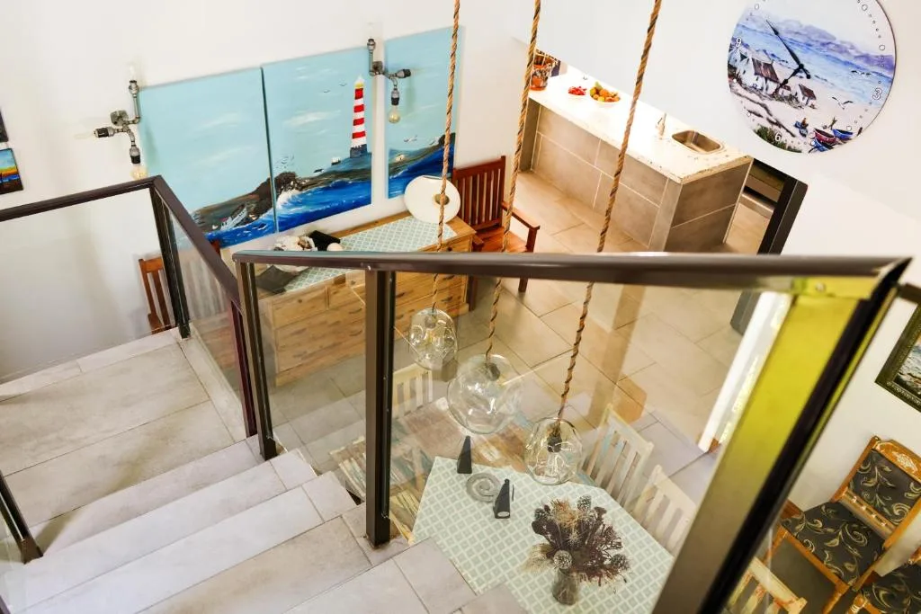 Interior staircase with rope swing and coastal artwork decorations