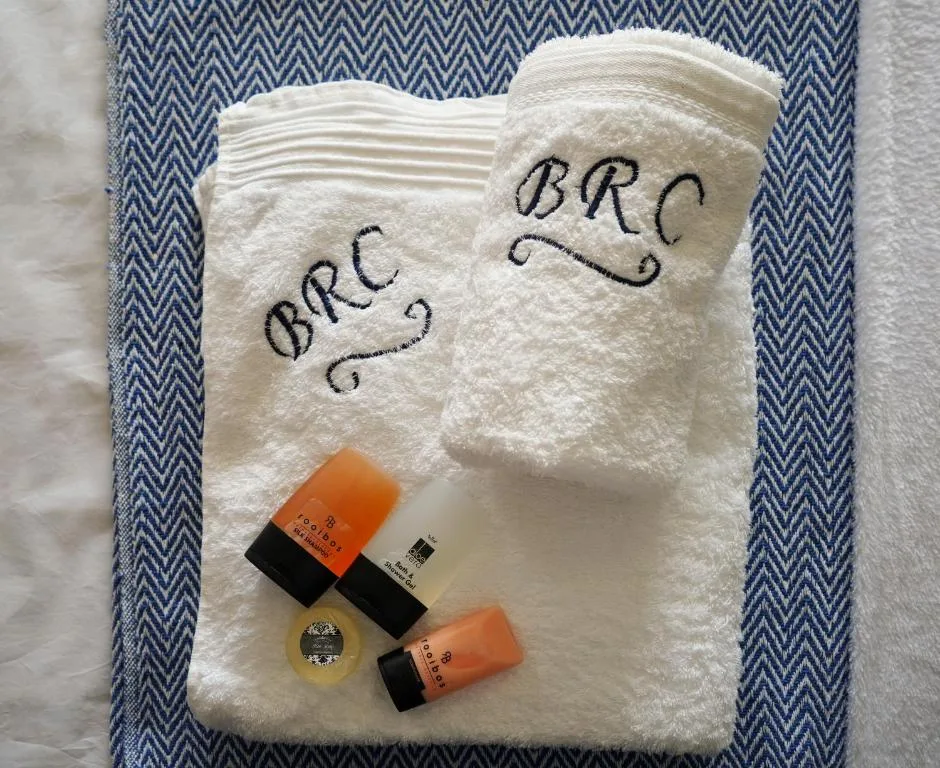 Monogrammed towels and luxury toiletries arranged on chevron patterned mat