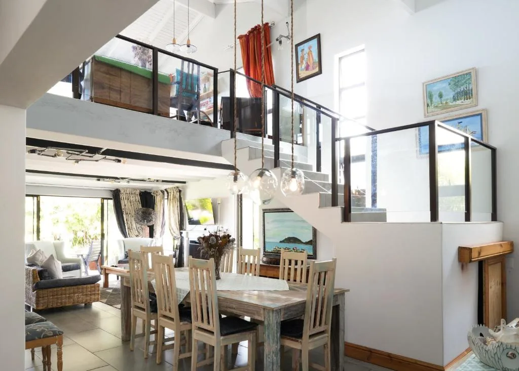Open-plan dining area with wooden table and chairs, mezzanine level above