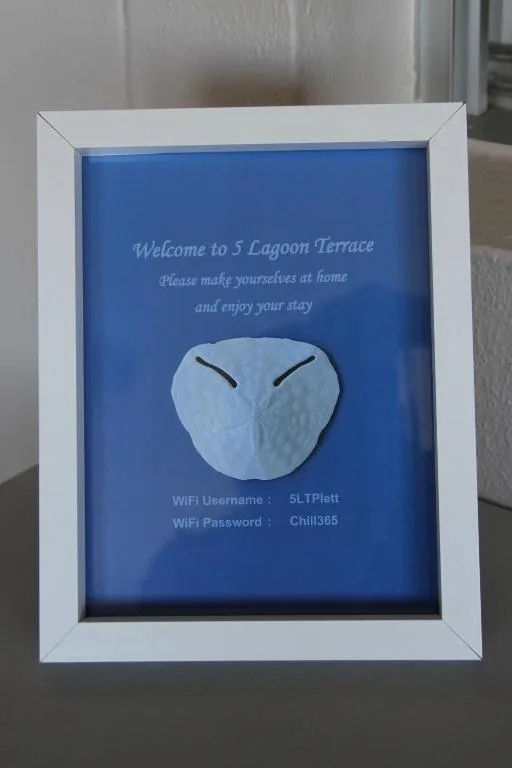 Welcome sign with WiFi credentials and decorative sand dollar art