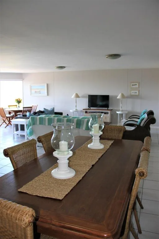Wooden dining table with woven chairs and coastal decor setup