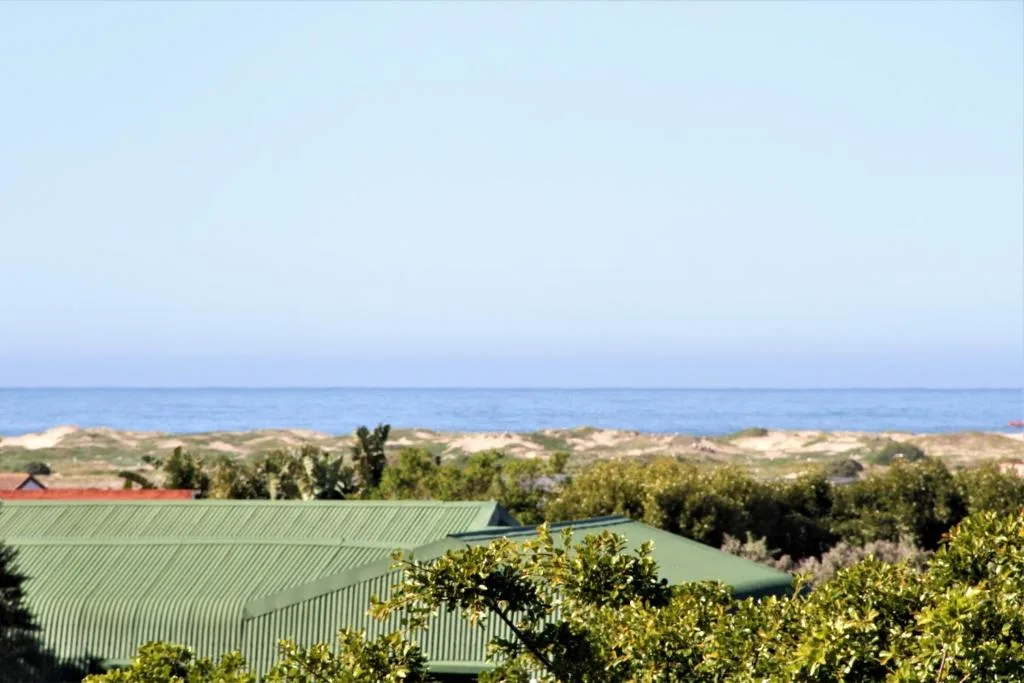 Scenic coastal view with lagoon, dunes, and ocean horizon beyond