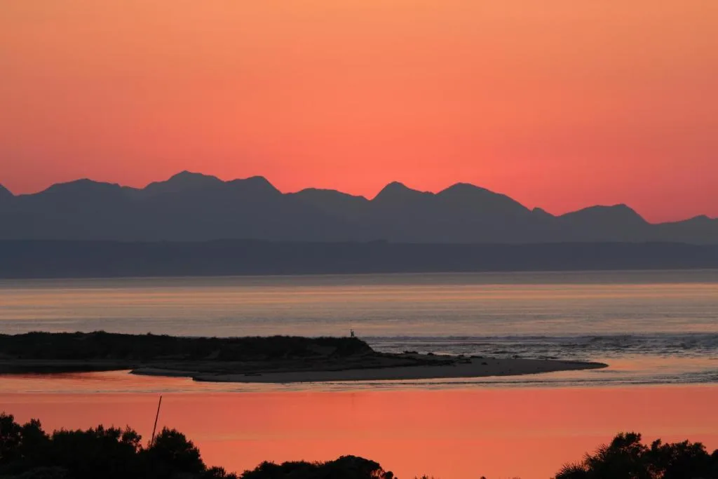 Stunning sunset over Plettenberg Bay lagoon with dramatic mountain silhouettes