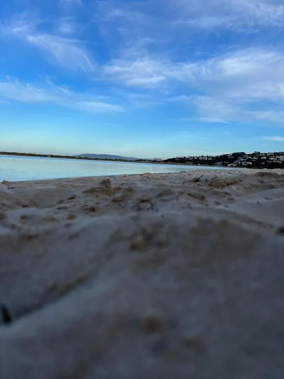 Scenic beach and lagoon view with coastal homes and blue sky
