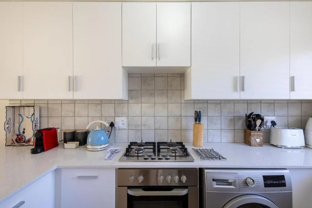 Modern kitchen with white cabinetry, gas cooktop, and stainless steel appliances