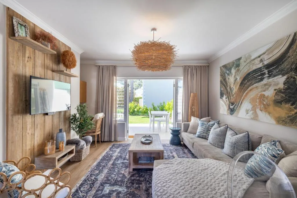 Spacious living room with comfortable seating and ocean views through glass doors