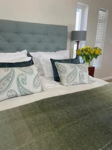 Spacious bedroom with upholstered headboard and fresh white bedding