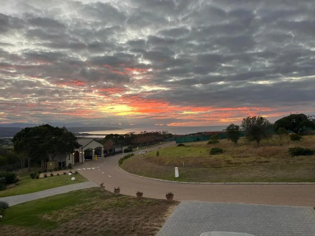 Dramatic sunset over property with lagoon and mountains visible