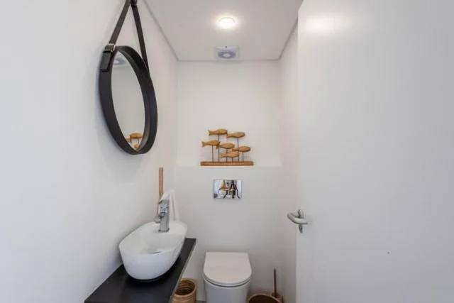 Modern bathroom with white sink, toilet, and decorative wall accents