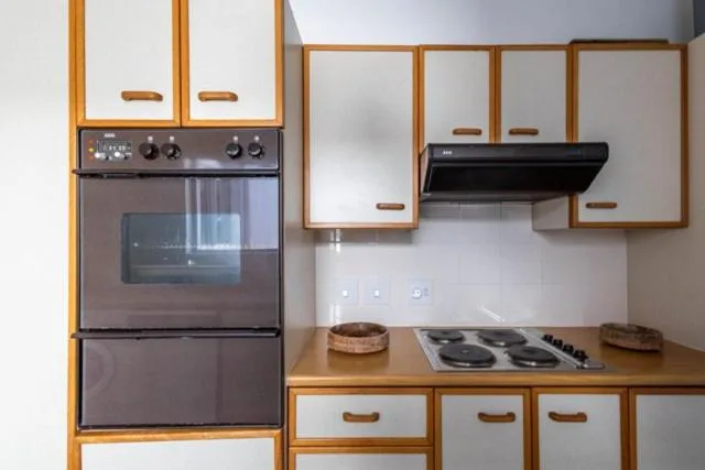 Modern kitchen with wooden cabinetry, built-in oven, and gas stovetop