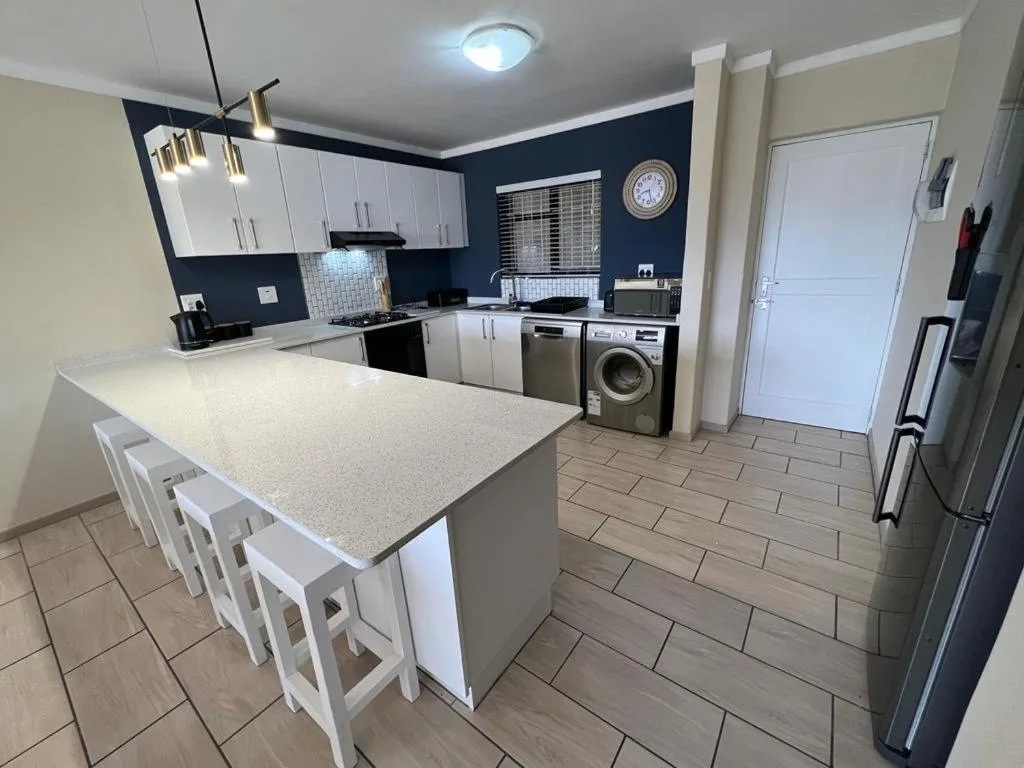 Modern kitchen with white cabinetry, island counter, and stainless steel appliances